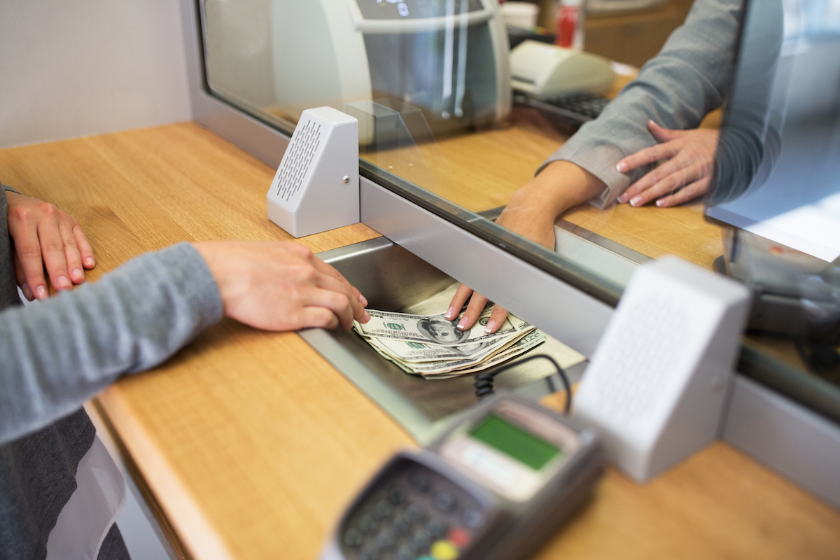 Person withdrawing money from bank teller