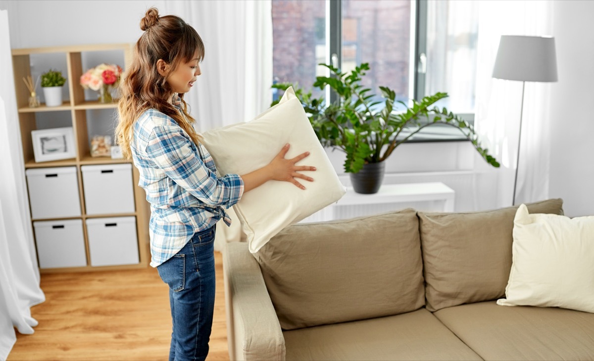 woman folding pillow in air