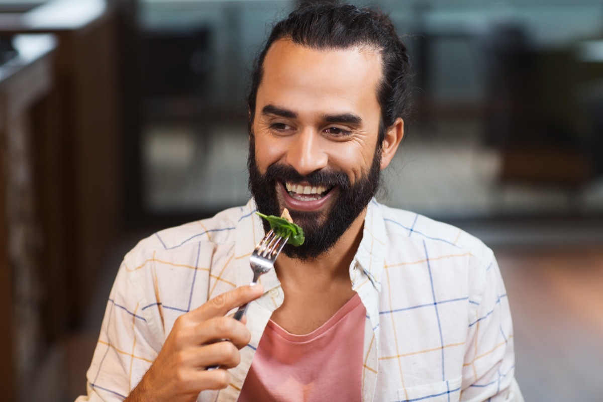 happy man with friends having dinner at restaurant