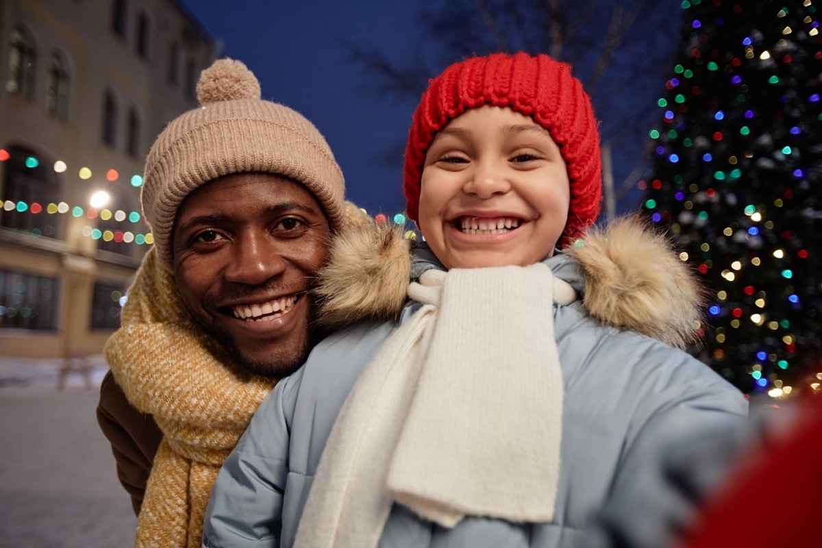 Man and child posing in front of Christmas tree