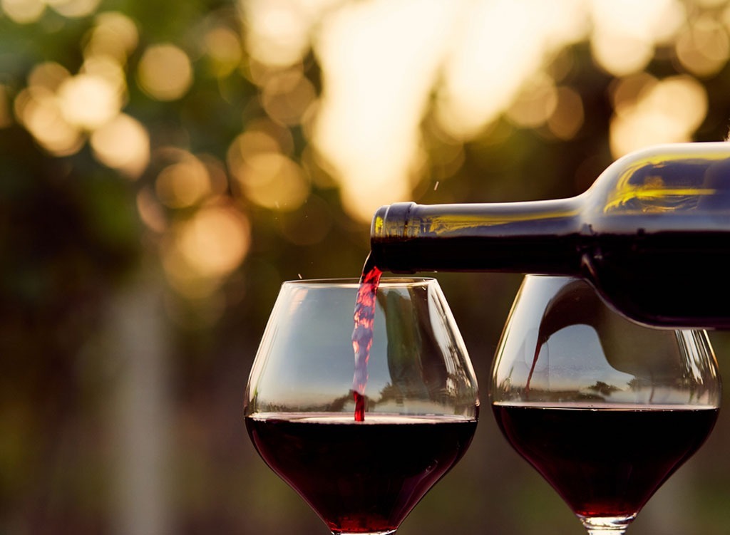 Red wine being poured into two glasses