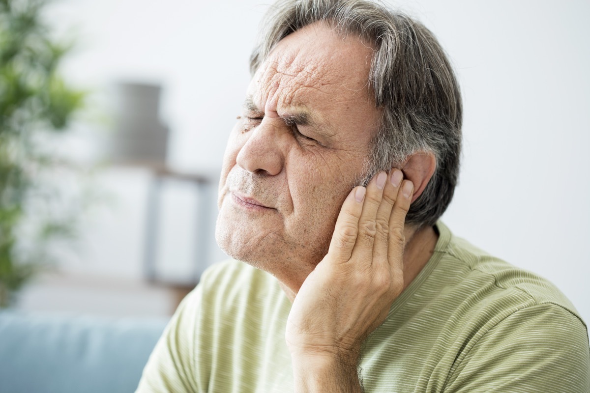 Senior white man holding his ear in pain