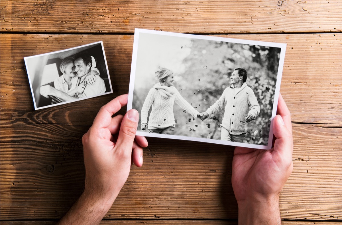 Hands holding pictures of senior couple. Studio shot, woo