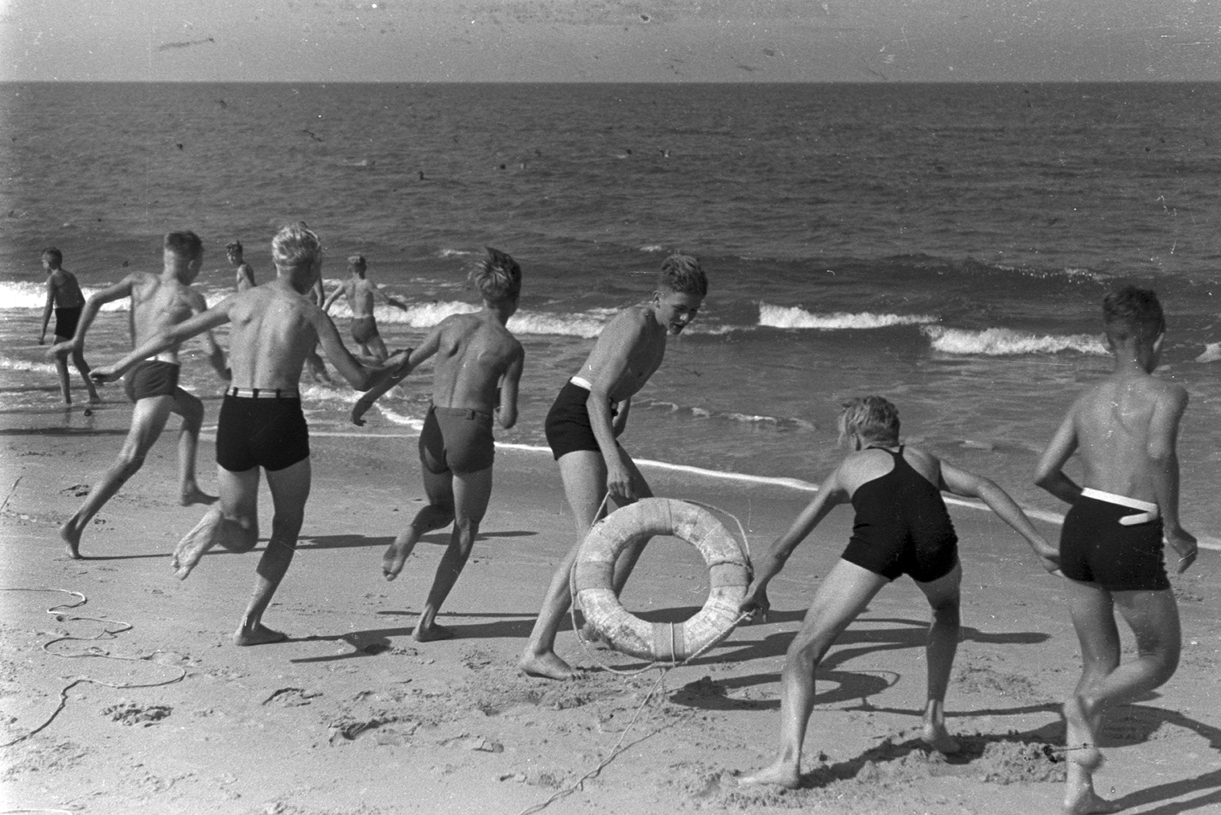 a group of young boys run into the water