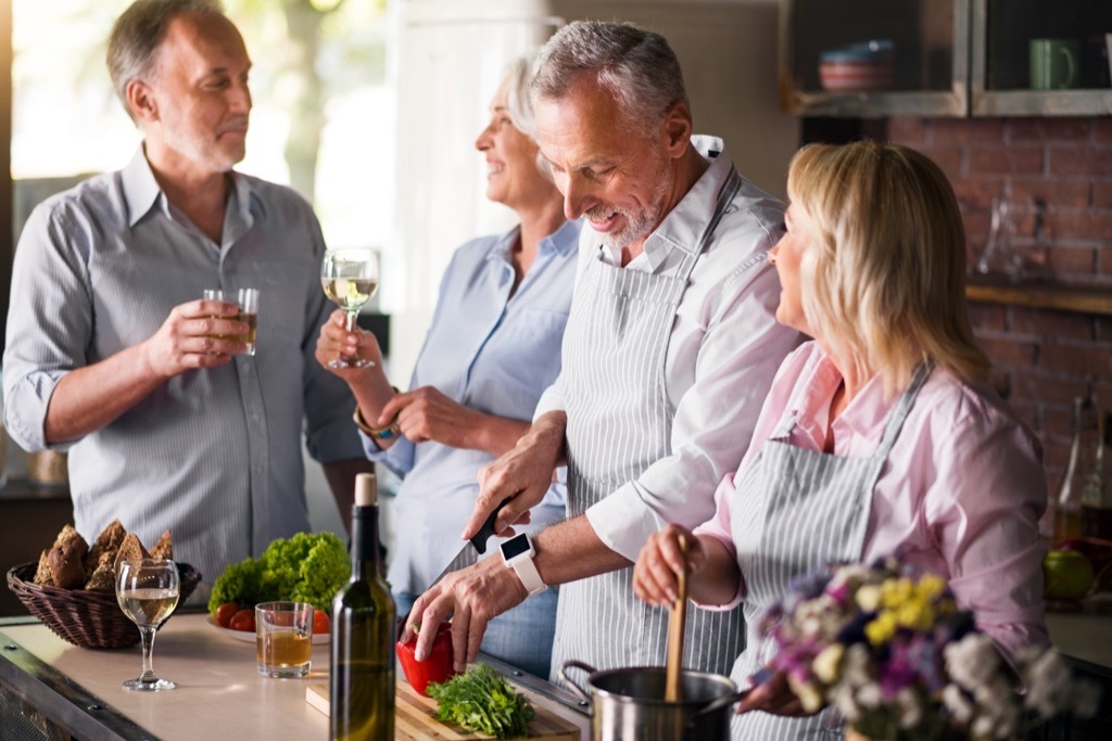 middle aged friends laughing in kitchen