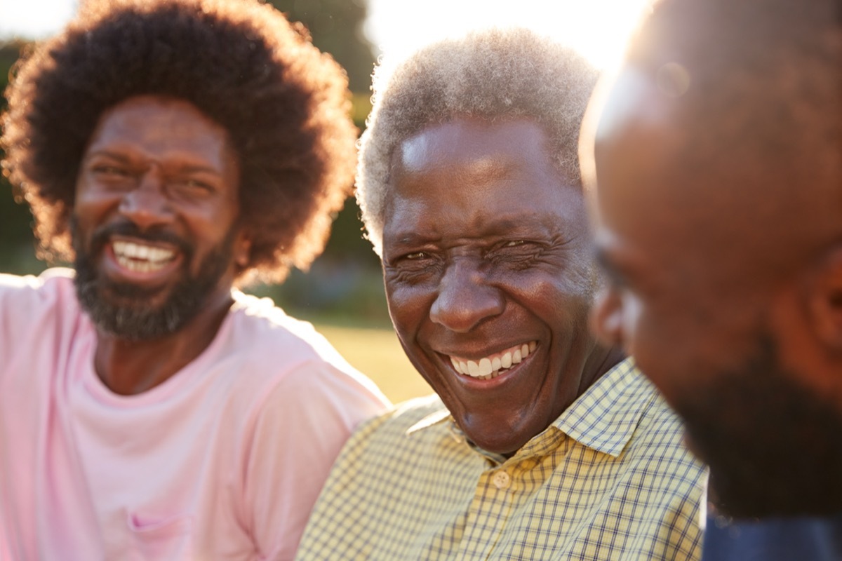 older man laughing with his two adult sons