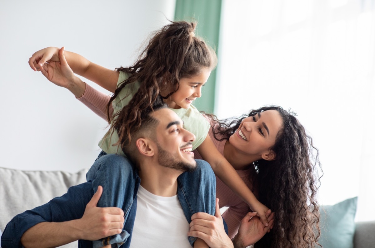 Family on couch together, smiling. 