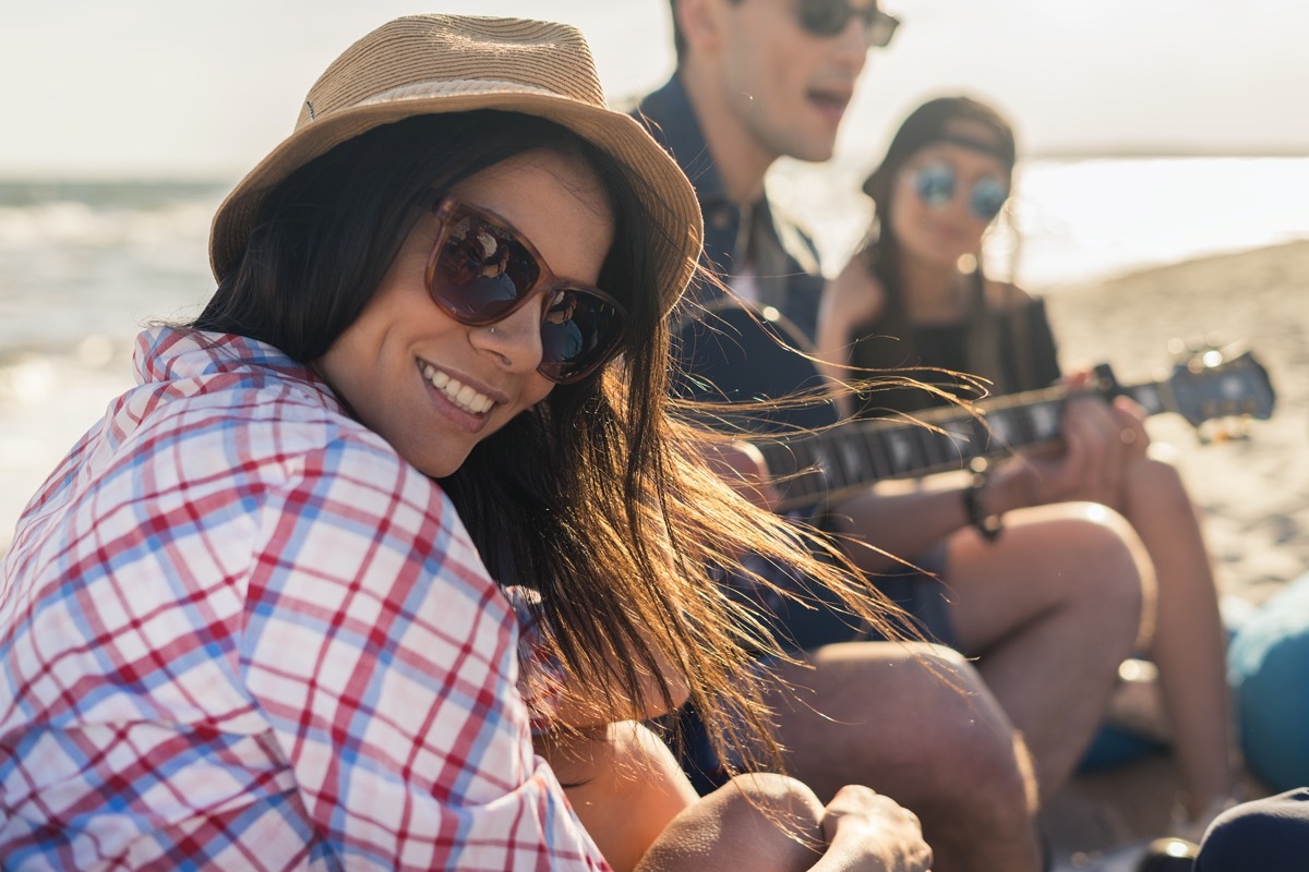 Woman in hat is smiling and looking at camera