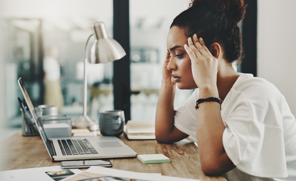 Shot of a young businesswoman looking stressed while using a laptop in her home office