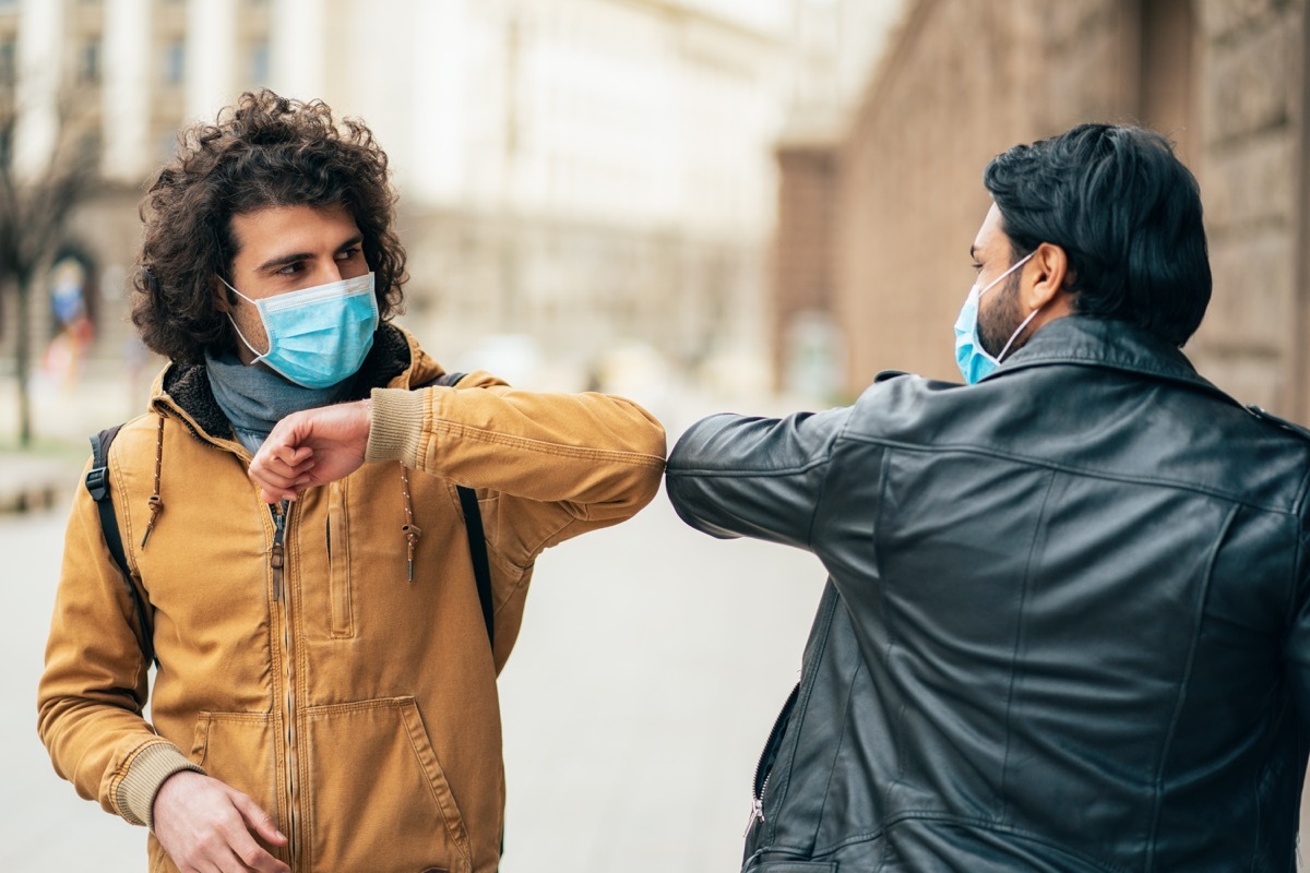 Young people friends meeting in quarantine and greeting without touching their hands