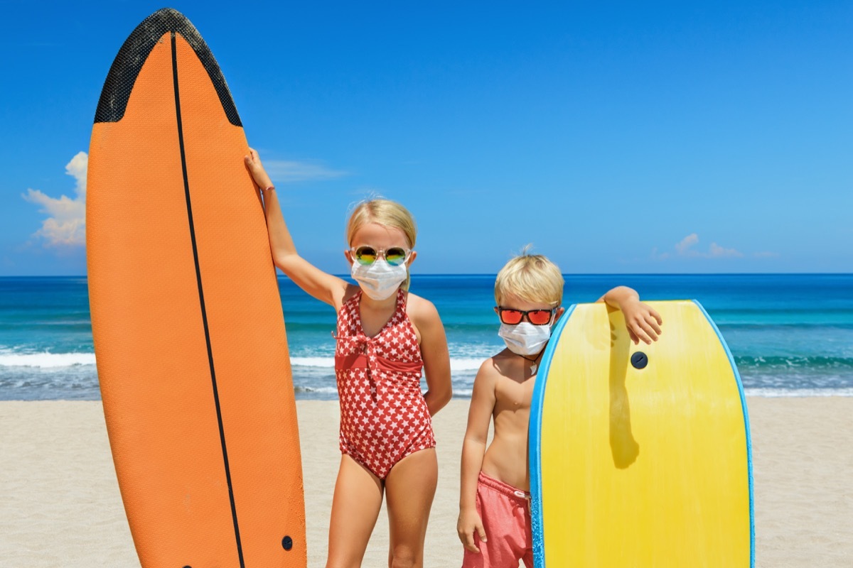 Kids wearing face masks on the beach to stay safe