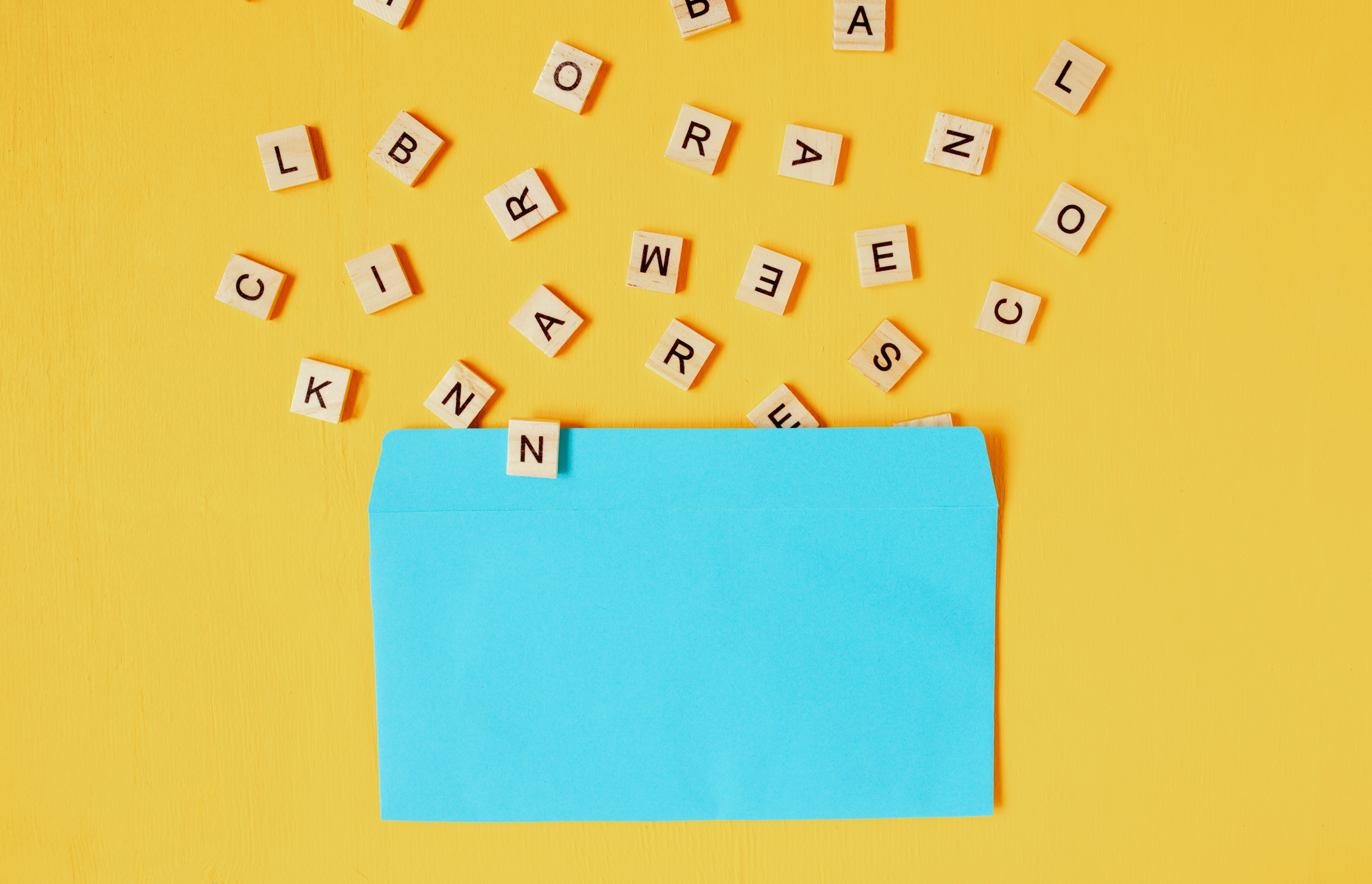 wooden letters pouring out of a blue envelope