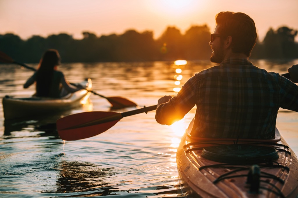 Man and woman kayaking at sunset