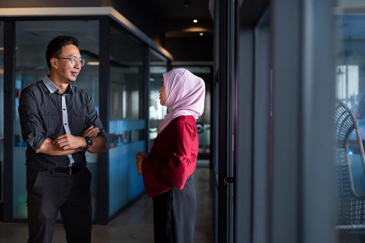 CEO having discussion with company secretary outside the board room.