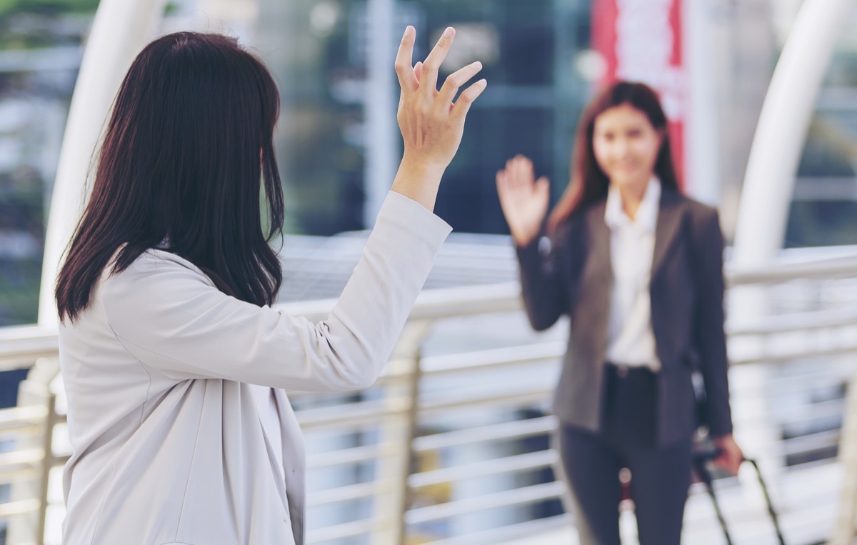 two woman waving hello in the street as they pass each other, old-fashioned etiquette rules