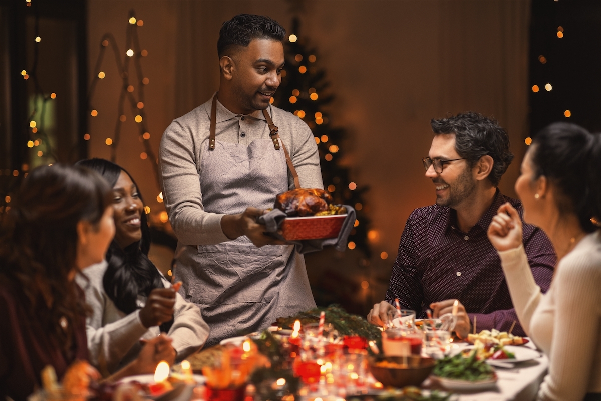 A multiethnic group of happy friends having Christmas dinner at home