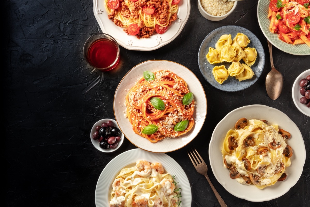 bowls of different kinds of pasta on black table