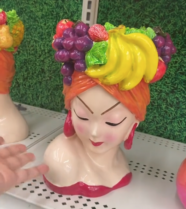 Woman with a fruit hat planter on a shelf