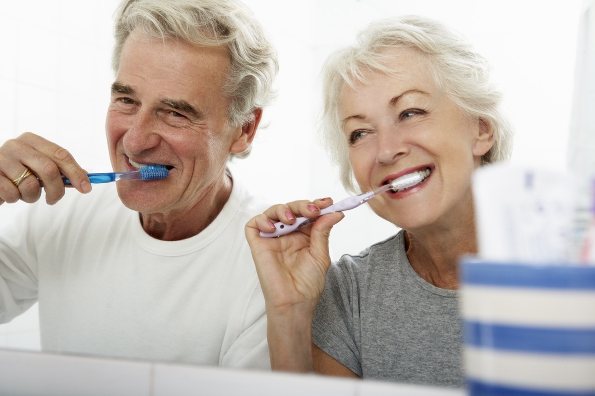 Older couple brushing their teeth in the bathroom