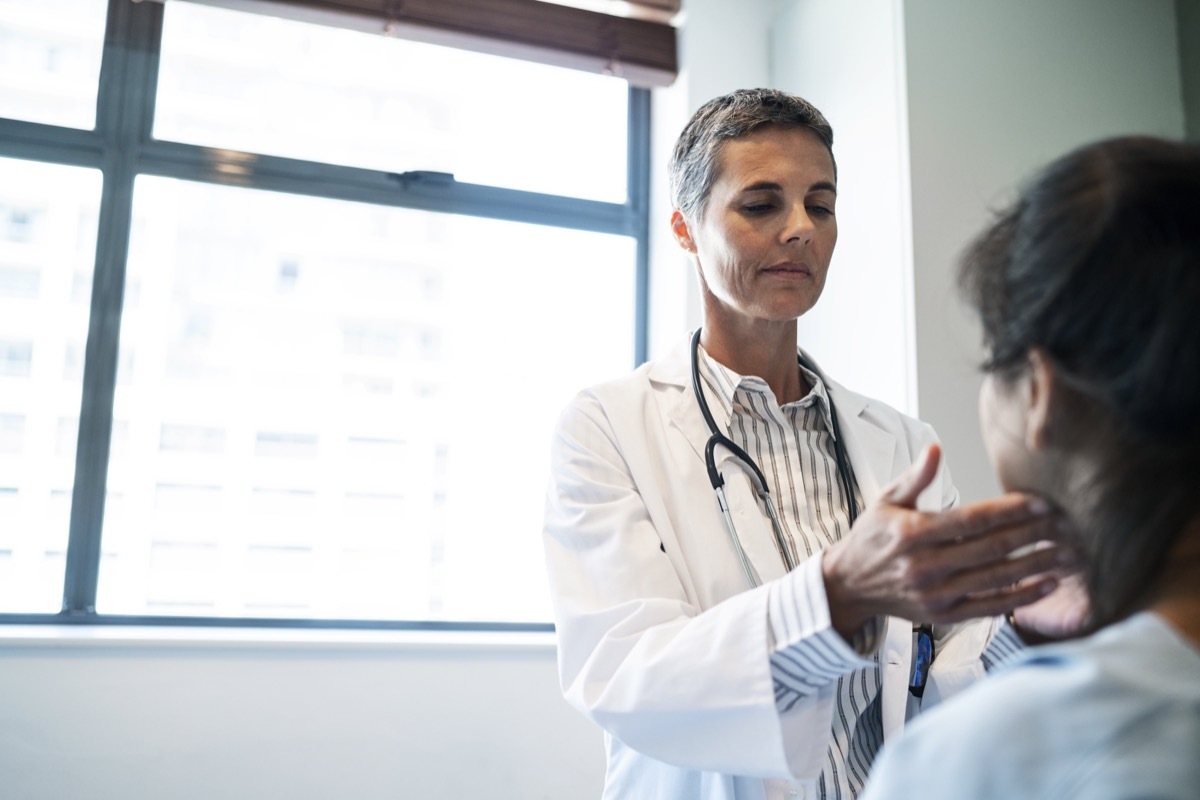 doctor examining her patient's throat