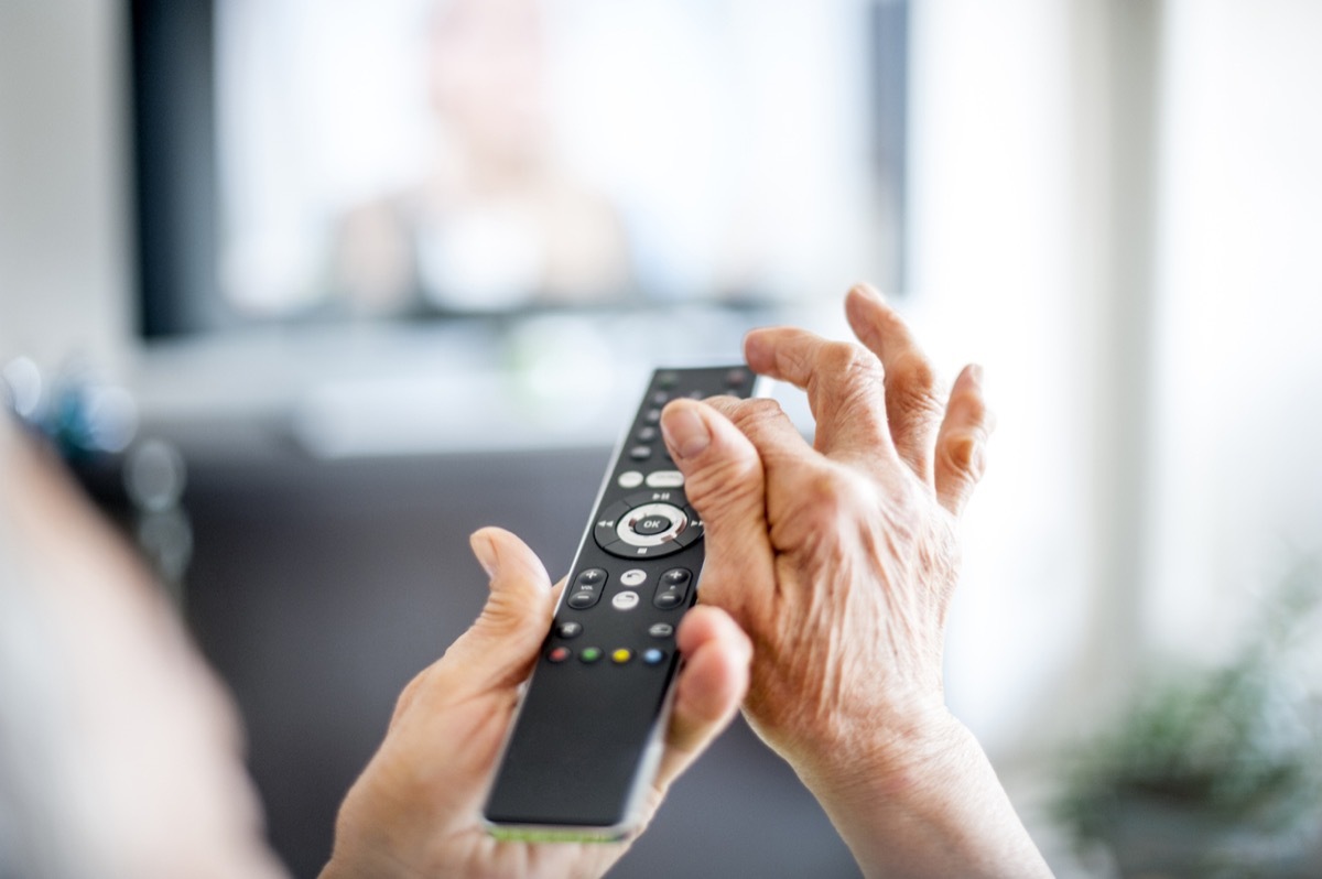 Close Up Hands Of Senior Woman Using TV Remote Control