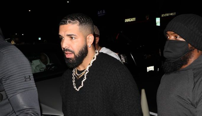 Rapper Drake walking into a restaurant surrounded by a security detail.