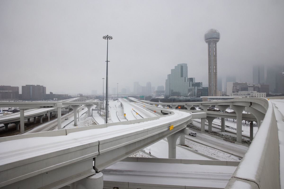 Pedestrians walk snowy streets in downtown streets during rush hour in downtown Dallas