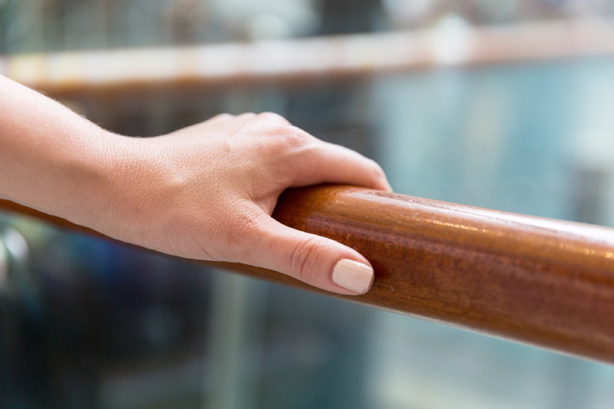 white woman holding hand rail