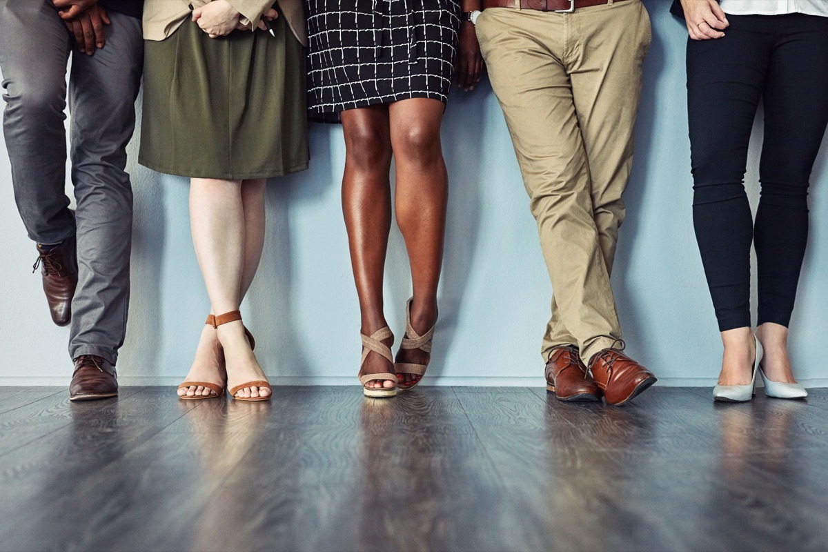 Studio shot of a group of unrecognisable businesspeople standing in line against a grey background