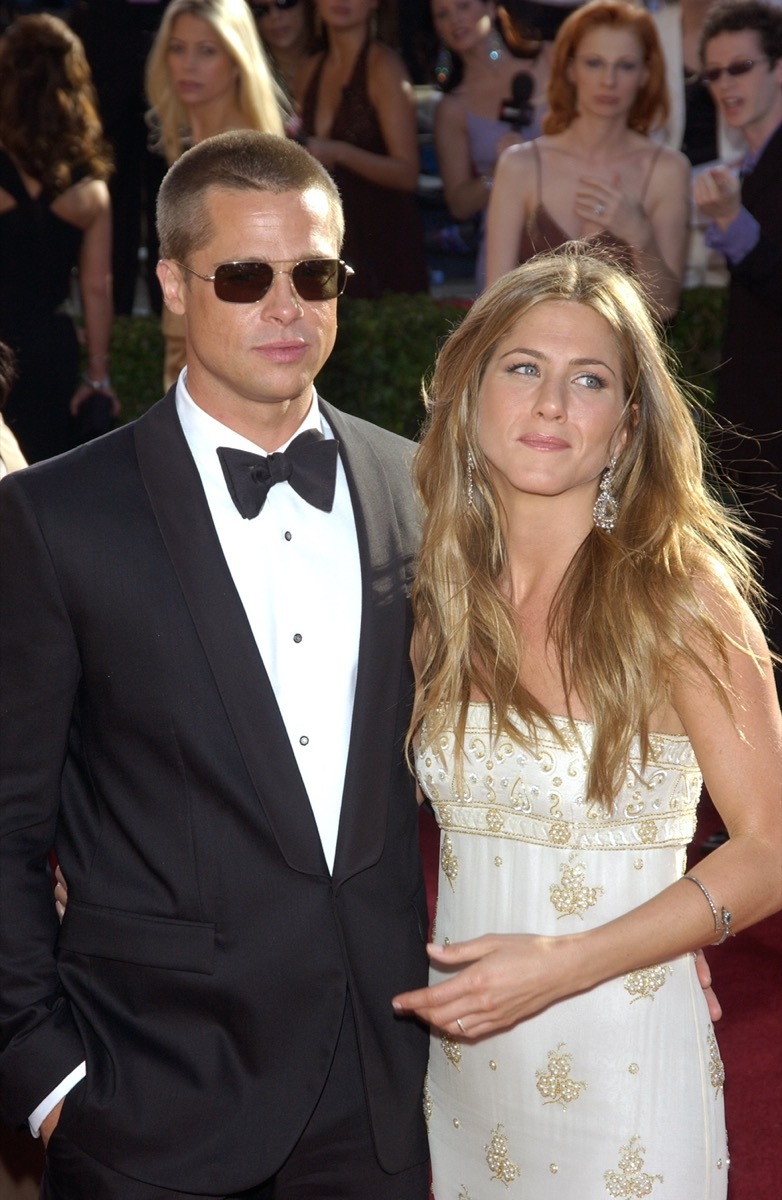 Jennifer Aniston wears a white dress and Brad Pitt wears a black suit on the red carpet at the Emmy Awards in 2004