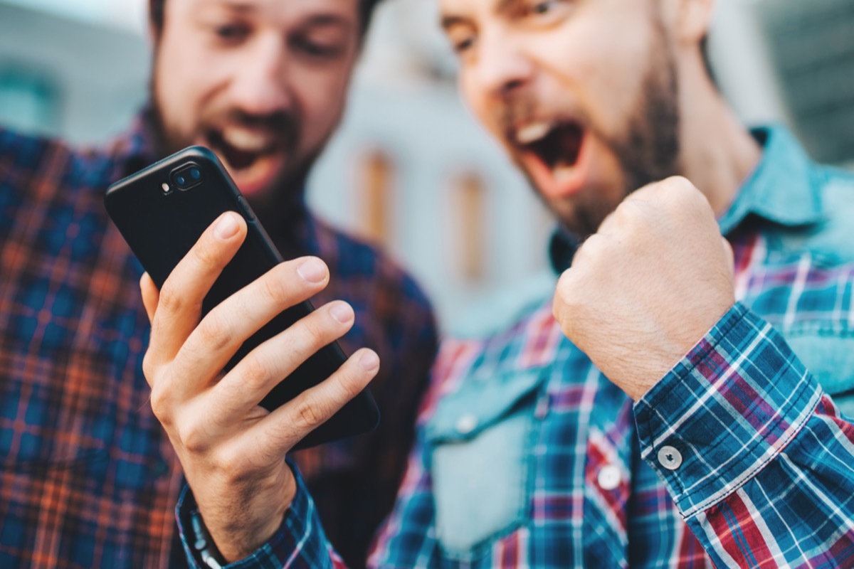 two men watching sports on phone