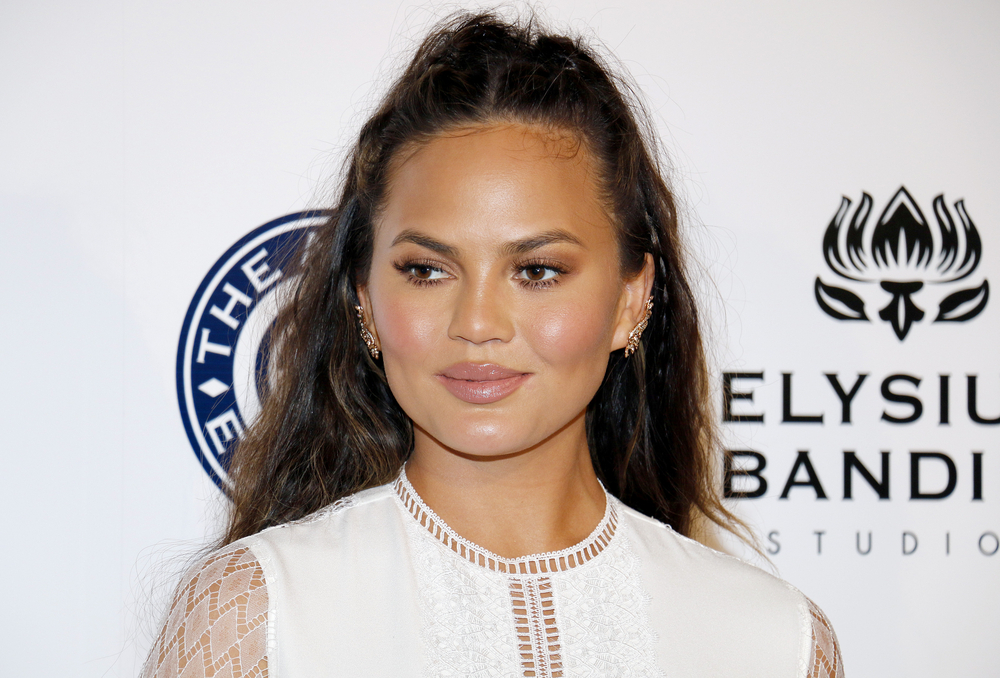 Chrissy Teigen in a white dress on the red carpet