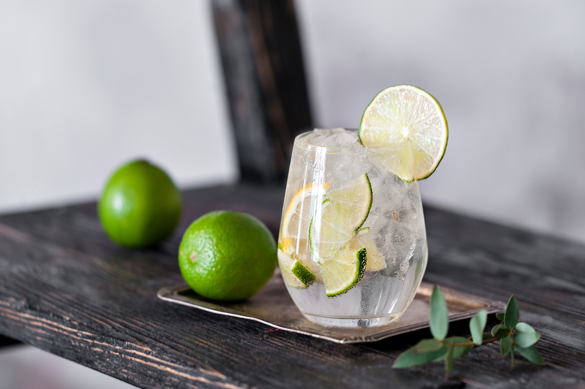 gin and tonic with limes on vintage background