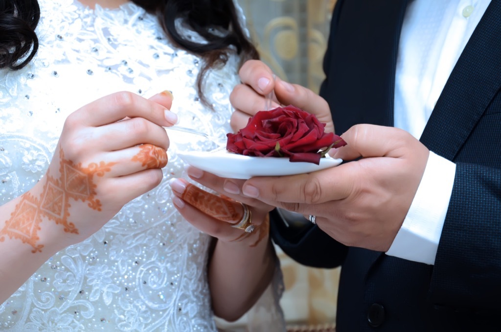 bride and groom eating wedding cake this is the age most people get married in every US state