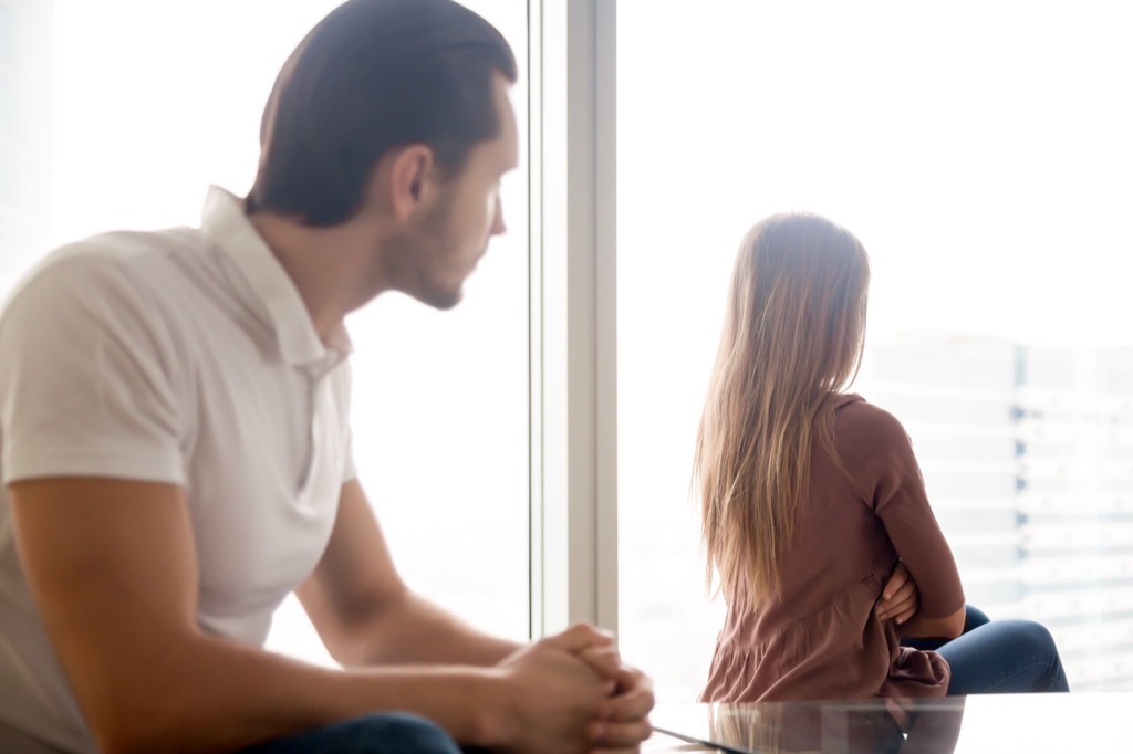 upset woman looking out the window with man who needs to apologize, signs of cheating