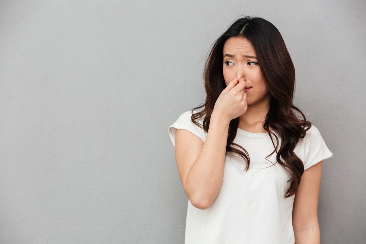 woman holding her nose from a bad smell