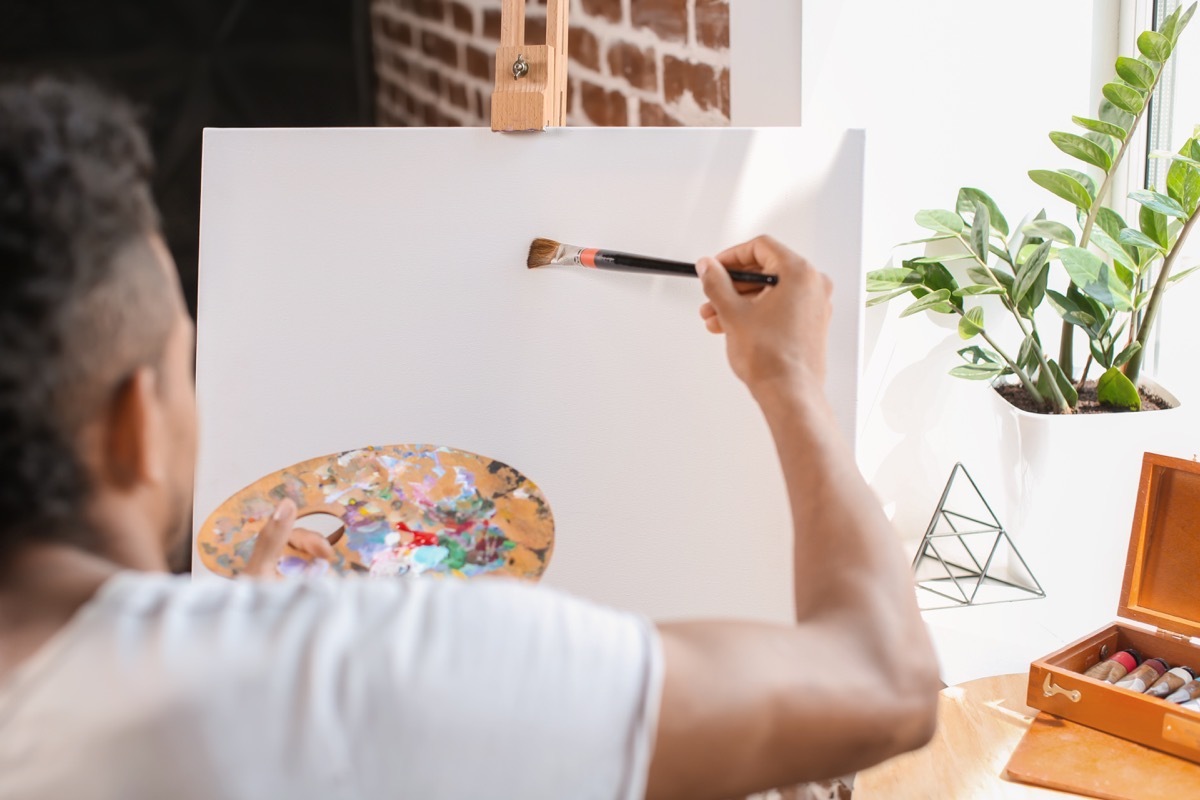 African-American man painting on canvas