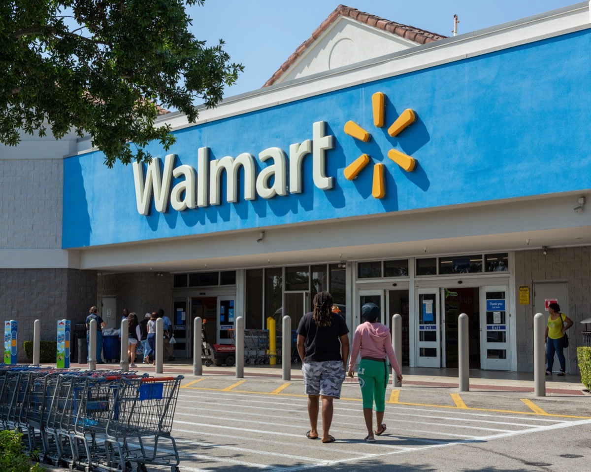 people walking into a walmart store on a sunny day