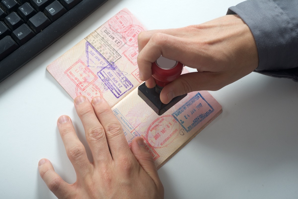 immigration officer putting stamp on passport