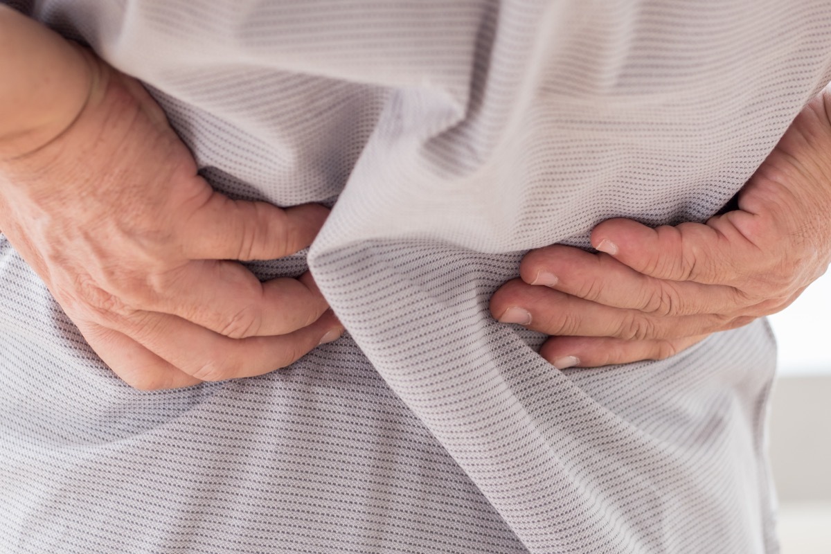 man putting hands on back to feel muscles, over 50 fitness