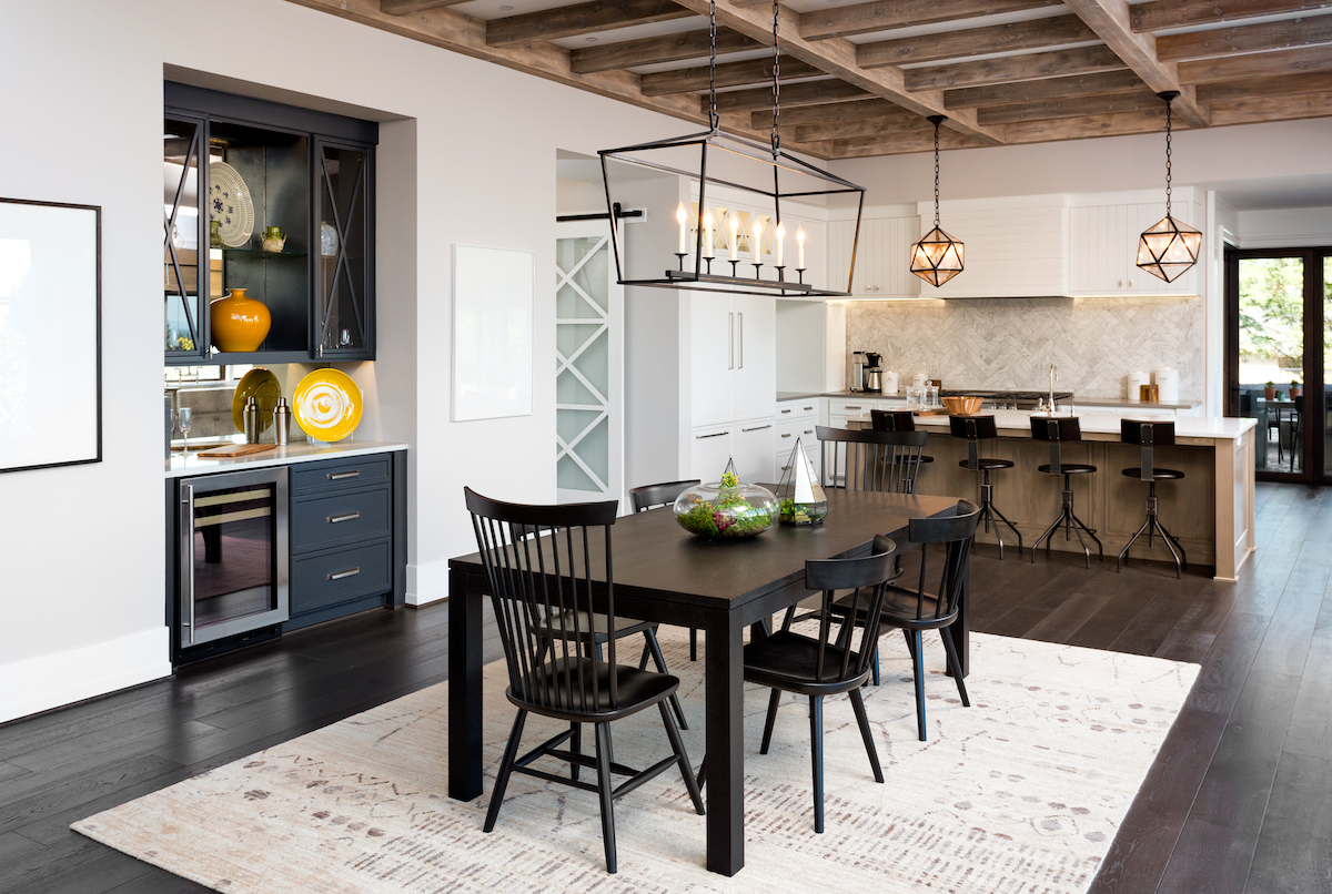 A modern farmhouse-style kitchen/dining room with a beamed ceiling