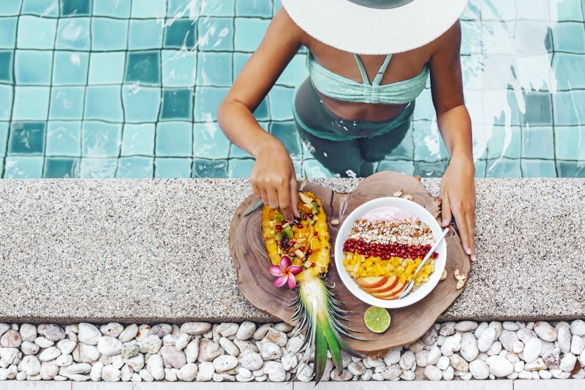 woman enjoying fruit plate with pineapple