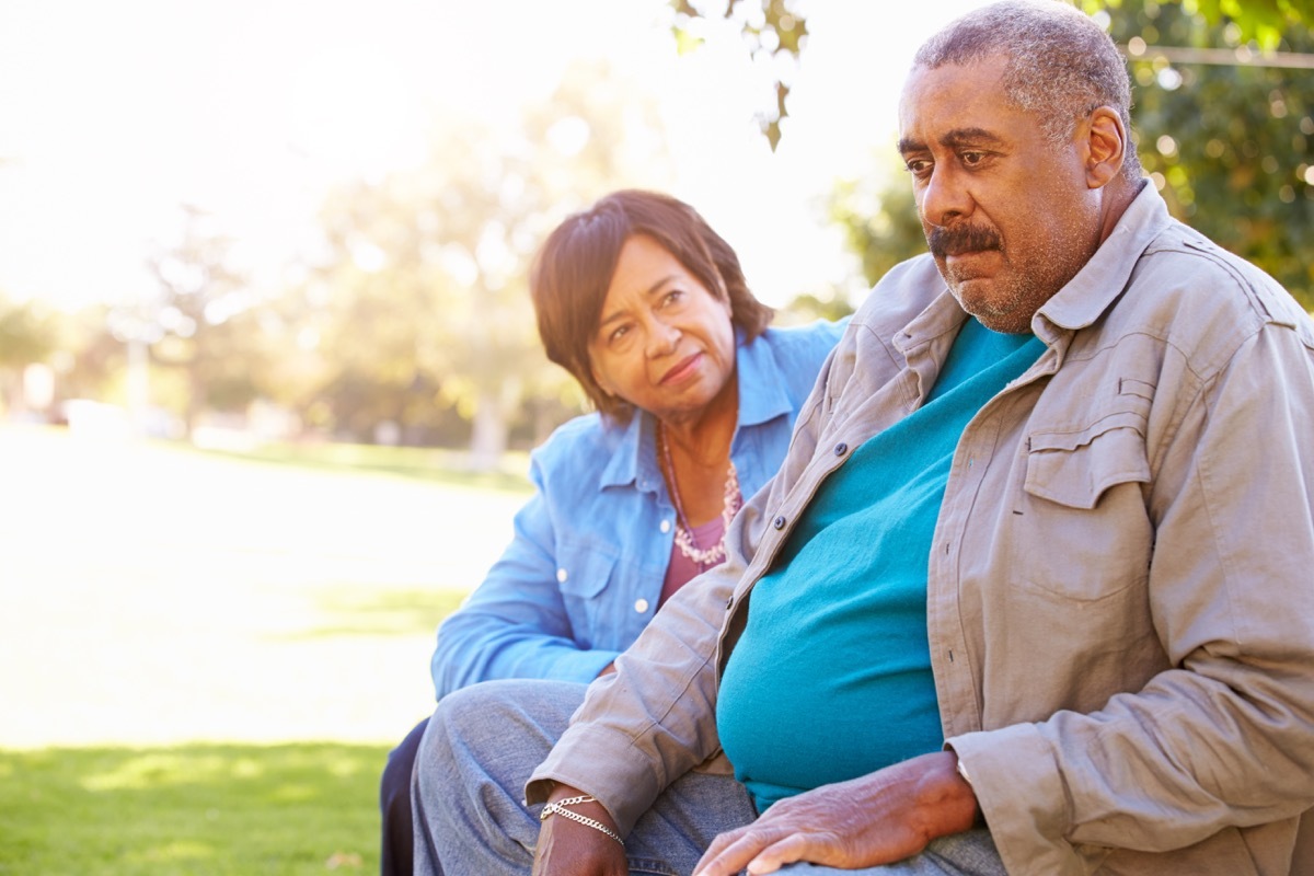 woman and man talking on a bench outside