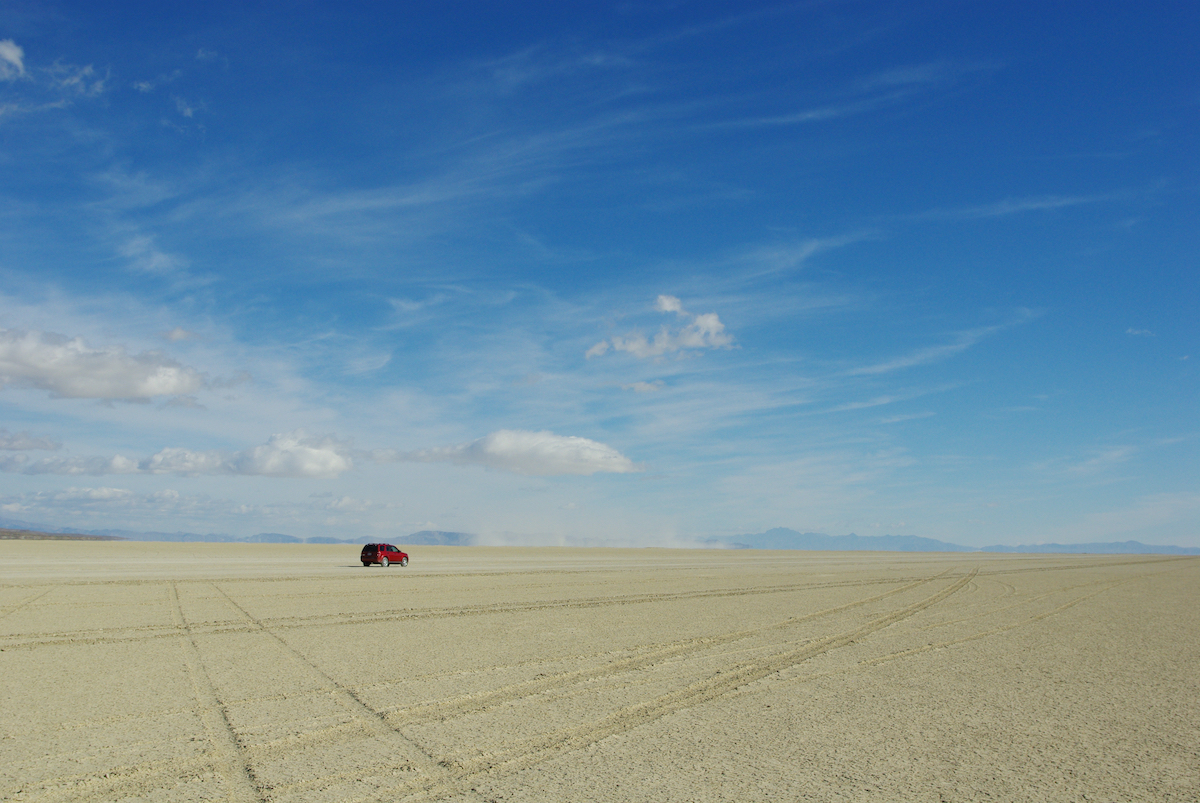 lone car in the middle of black rock desert