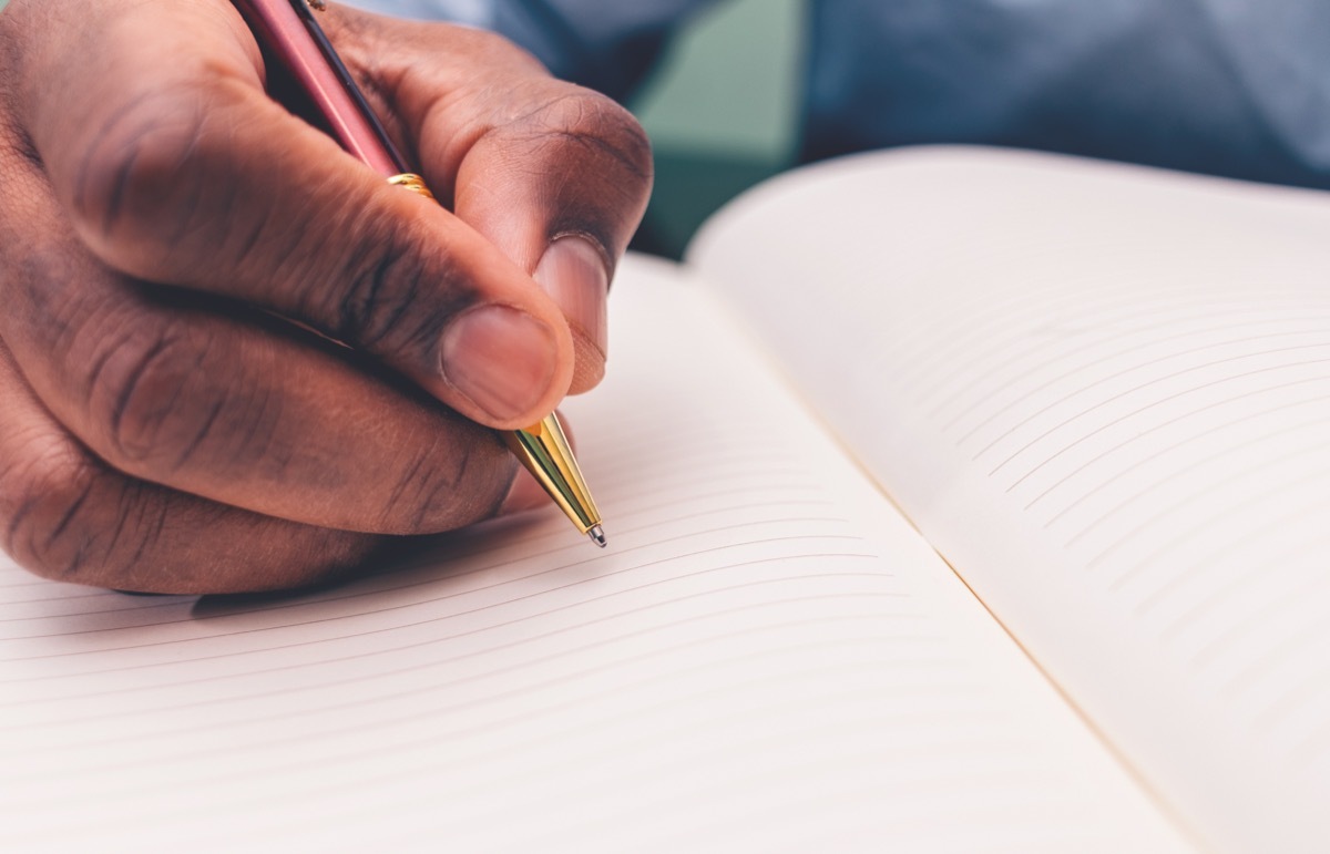 Black man writing in a notebook