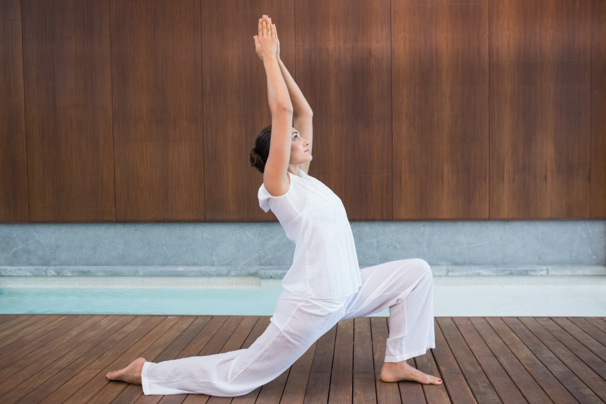 Content brunette in white doing tai chi in health spa