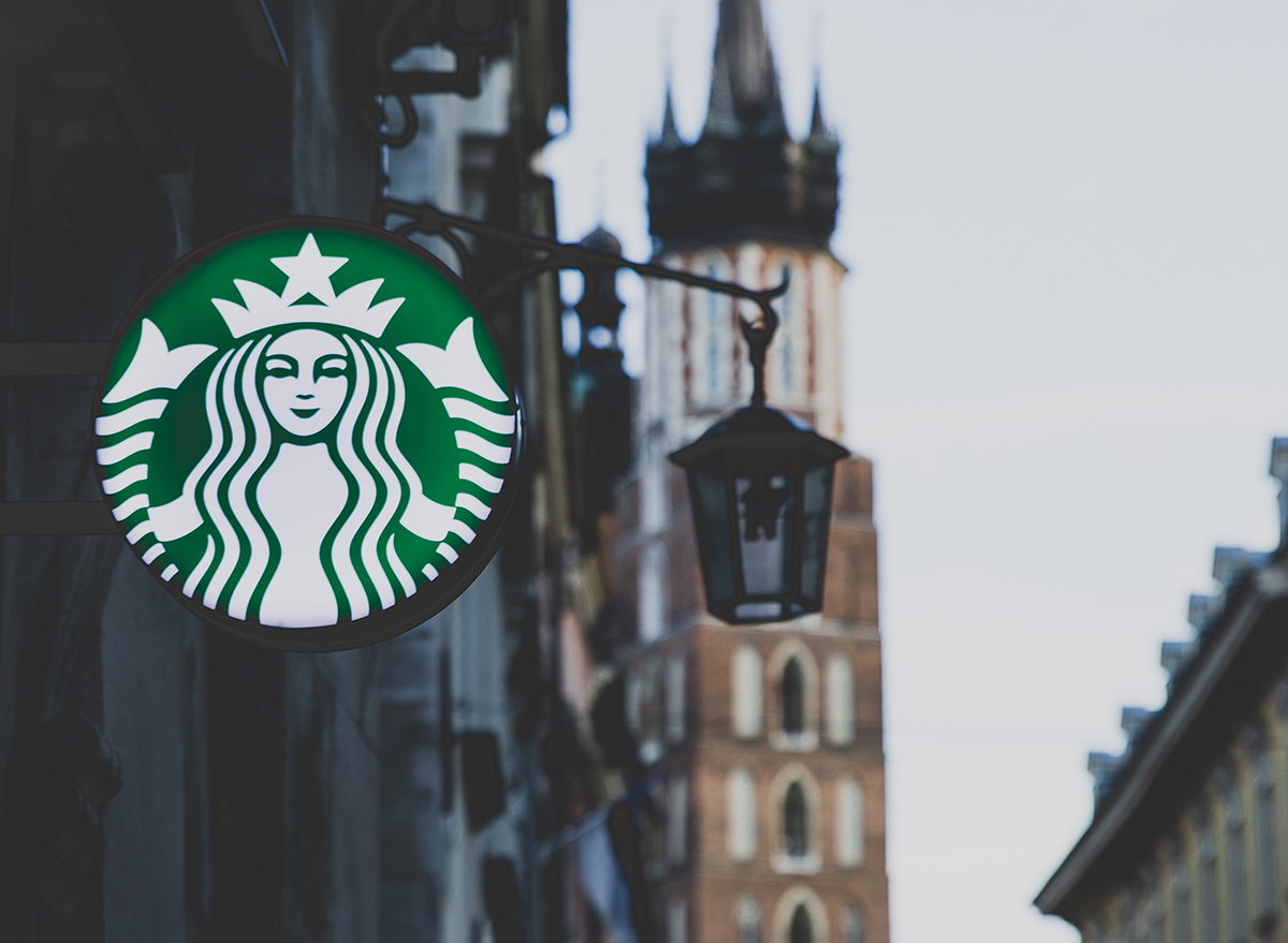 Starbucks sign glowing in a city