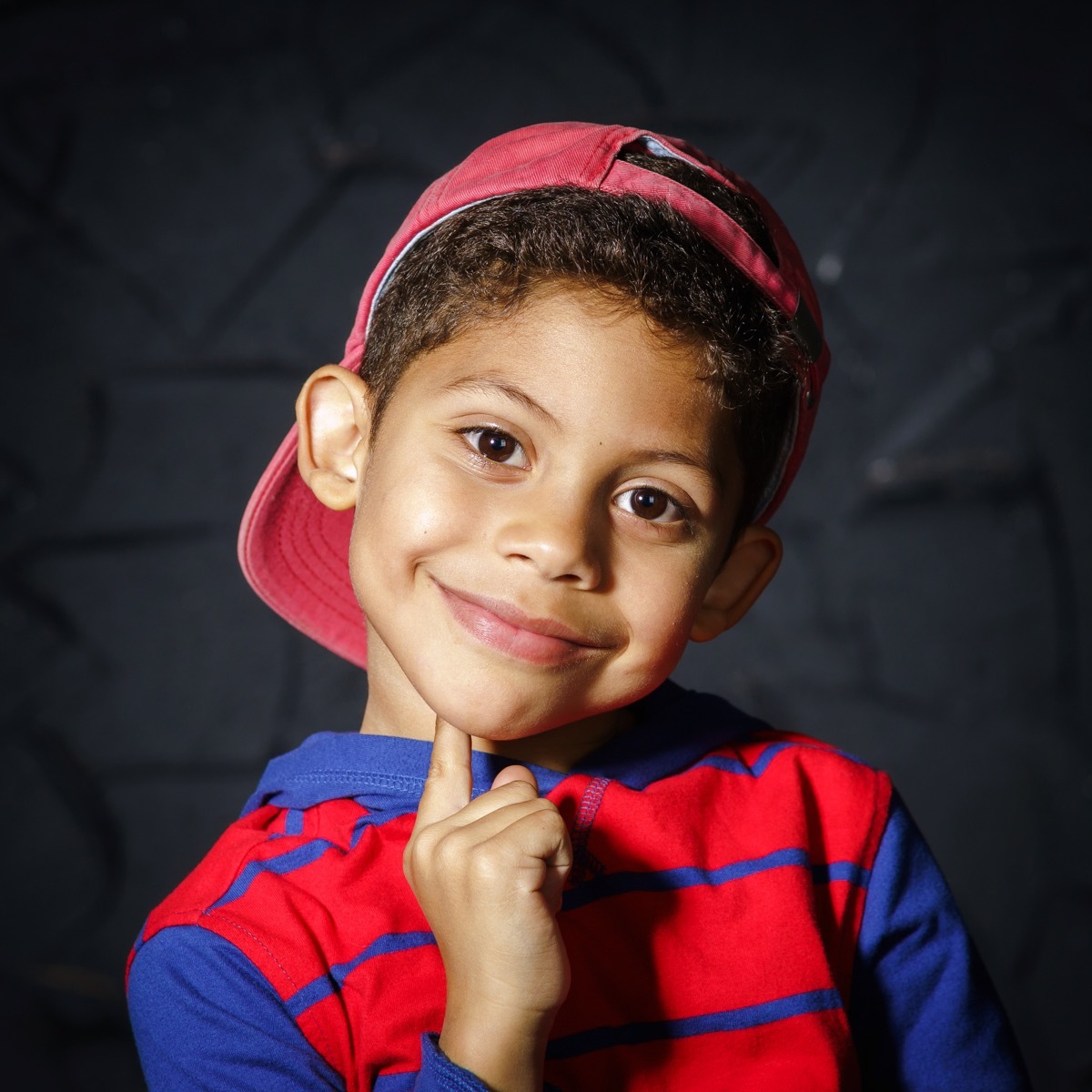 Young boy wearing a backwards hat smiling