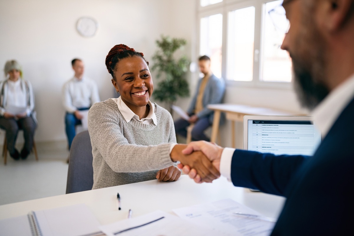 male recruiter shaking female applicant's hand during job interview