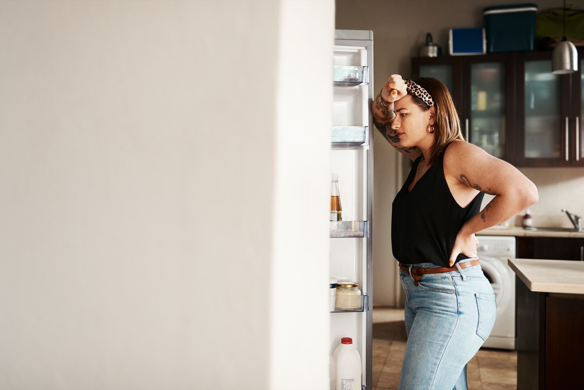 Shot of a young woman searching inside a refrigerator at home